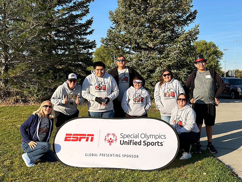 Group of students and teacher in front of ESPN Special Olympics sign