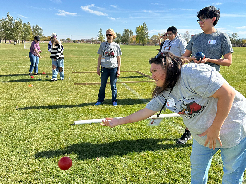 Female students throwing a ball during an outside Special Olympic events
