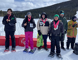 Class of students wearing medals and snow shoes in the snow