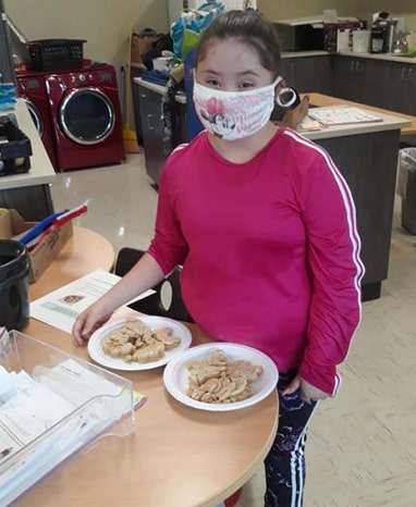 Student with plates of cookies