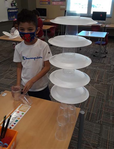 student stacking cups and plates
