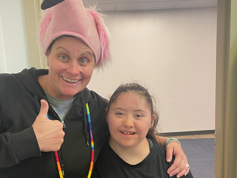 Teacher giving thumbs up next to happy student